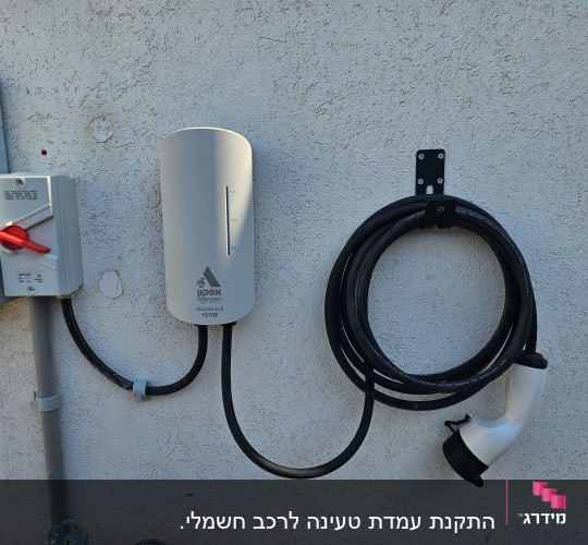 עמדת טעינה לרכב חשמלי עם כבל מחובר לקיר